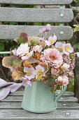 Pink autumn bouquet on garden chair Zinnia, rose, anemone