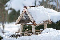 Snowy birdhouse with great tit and greenfinch