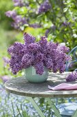 Lush Syringa vulgaris 'Sensation' bouquet in turquoise vase