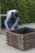 Gravel terrassse with raised beds made of hazelnut rods