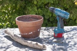 Building flower pot out of clay pot and driftwood