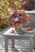 Autumn bouquet with perennials and fruits in basket vase