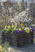 Gravel terrassse with raised beds made of hazelnut rods