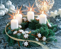 Advent wreath made of branches, cinnamon stars and white candles