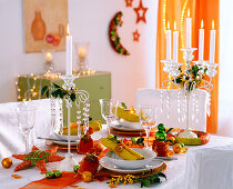 Table with candlesticks, star, tree ornaments, Ilex 'Bacciflava' (holly)