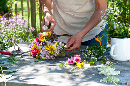 Tying colorful summer flowers wreath