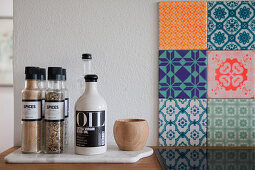 Spices and oil bottle next to patterned tiles