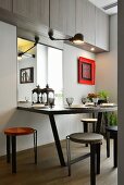 Minimalist dining area below wall-mounted cupboards