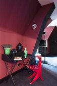 Schwarzer Retro Schreibtisch und roter Holzstuhl in Dachzimmer