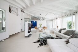 White couch, arc lamp and zebra-skin rug in elegant living area