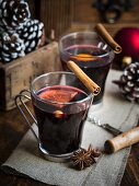 Zwei Gläser Glühwein auf rustikalem Tisch mit Weihnachtsdekoration