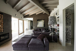 Grey sofa set, fireplace and glass wall in elegant lounge