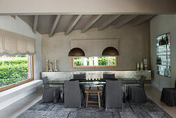 Grey Persian rug, loose-covered chairs and glass table in elegant dining room