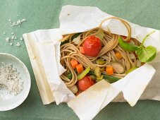 Spaghetti en papillotte with vegetables and basil oil