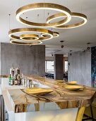 Circular brass light fittings above marble bar