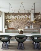 Retro metal chairs at white table and geometric wall tiles in elegant, open-plan kitchen