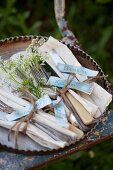 Cutlery and napkins tied with string and labelled with name tags