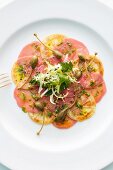 Veal carpaccio with lemon slices and capers (top view)
