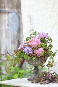 Luxuriant bouquet of hydrangeas and tendrils of berries in urn