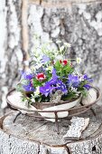 Arrangement of delphiniums and sweet Williams in metal dish