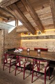 Classic chairs in rustic dining area below chunky wooden roof beams