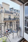 Metal furniture on balcony with view of house opposite