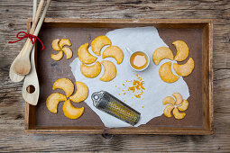 Orange moon-shaped biscuits on a wooden tray