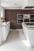 Moderne Wohnküche mit Kochinsel und dunklen Holzfronten