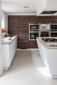 Island counter and dark wooden cupboards in modern kitchen-dining room