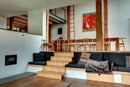 Split-Level Wohnbereich mit eingebauten Sitzmöbeln, Holztreppe und Galerie