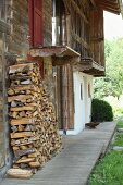 Firewood stacked against weathered wooden façade