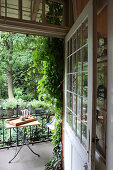 Tray on table in front of potted herbs on balcony