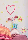 Rag doll leaning against wall decorated with washi-tape shapes