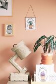 Elephant ear in painted terracotta pot next to paper lamp