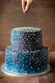 Zweistöckige blaue Torte mit Silberperlen