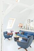 Retro Polstermöbel im Dachgeschoss mit weiss gestrichener Balkenkonstuktion