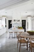 Island counter and dining table in large kitchen with concrete floor