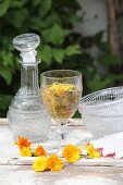 A dandelion smoothie in a glass beside a carafe