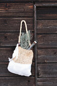 Hand-made cotton and raffia bag hung on wooden wall