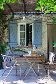 Vintage metal chairs and folding table on rustic terrace