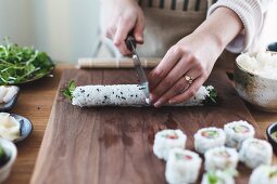 Suhsi zubereiten: Sushirolle in Stücke schneiden