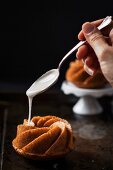 Mini-Erdnusskuchen in Kranzform mit Zuckerglasur glasieren