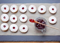 Biscuits on baking paper with a jam jar