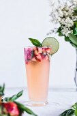 A glass full of Honey Sweetened Limeade with Strawberries and Basil