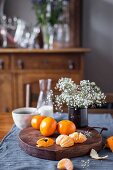 Clementines and flowers on a rustic wooden board