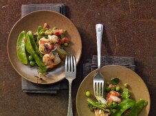 Prawns with sugar snaps, peas and tomatoes