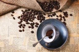 Stillleben mit Kaffeetasse, Kaffeepulver und Kaffeebohnen