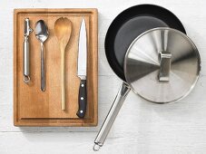 Various kitchen utensils: pan, peeler, spoon, knife