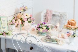 Easter table romantically set with delicate flowers and lit candles