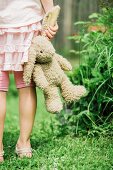 Little girl holding toy bunny by the ear